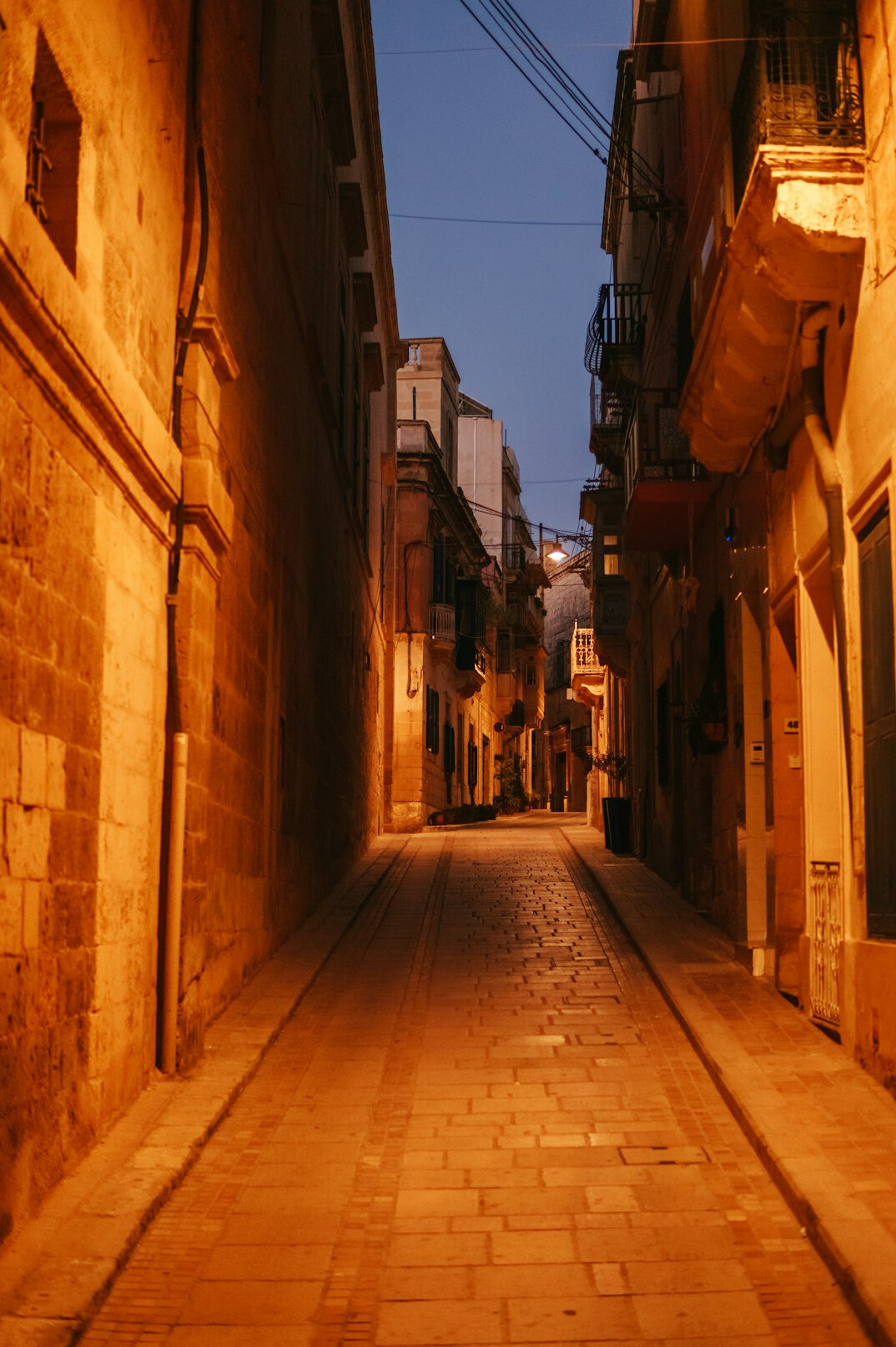 Quiet old city street in the evening with warm lights