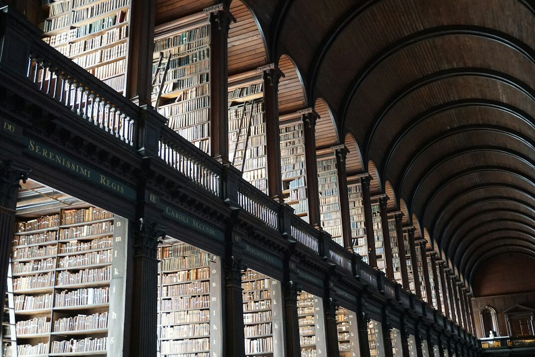 Old library with tall wooden shelves full of books